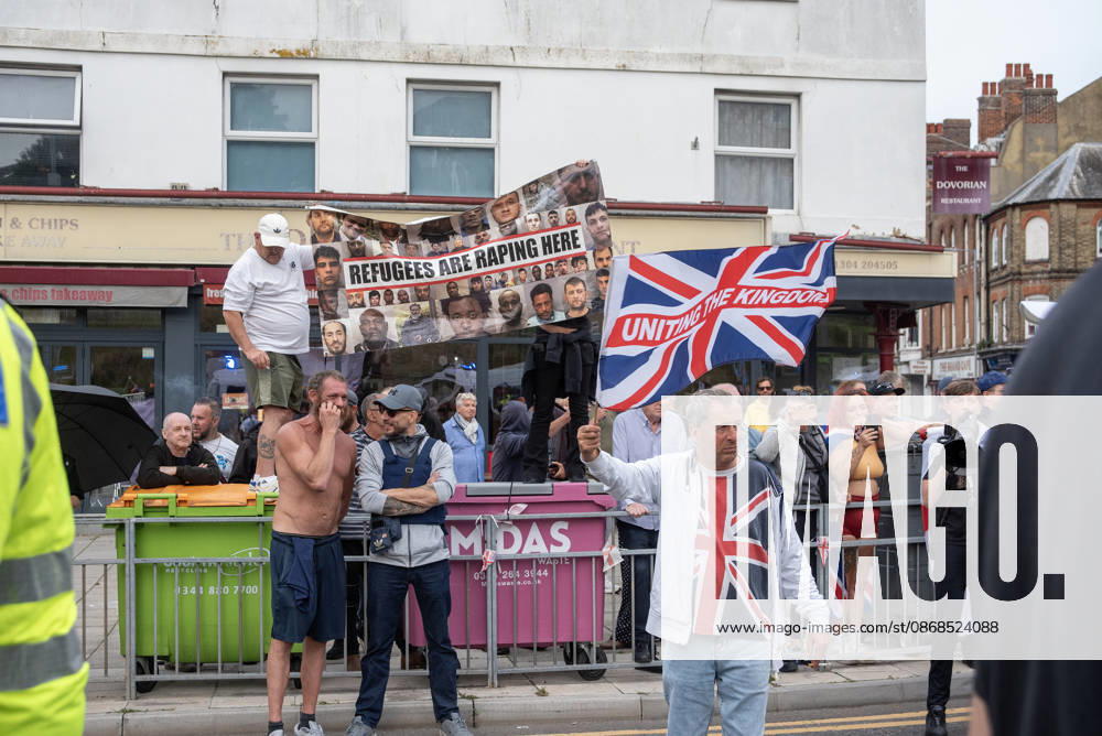 Far-right protesters hold a banner and wave a St George s flag during a demonstration in Dover. Supporters of the English Defence League (EDL) gathered in Dover, UK to march through the town all the way to the harbour. English Defence League is an extreme far-right and Islamophobic organisation. It was founded by Tommy Robinson (pseudonym of Steven Yaxley-Lennon) in 2009. Dover United Kingdom - ZUMAs197 20261003_aaa_s197_268