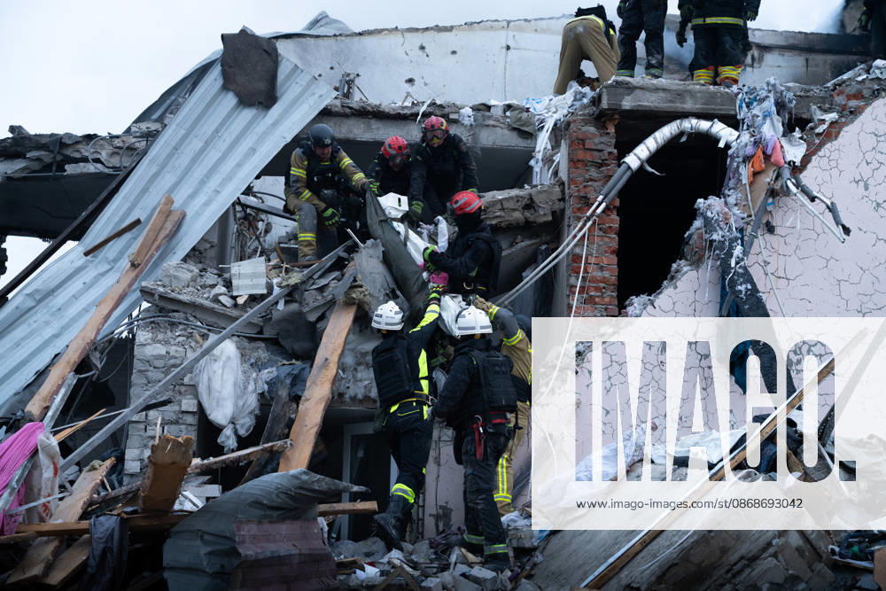 Local rescue workers, firefighters and Red Cross volunteers clear rubble following a Russian aerial attack on a bus repair warehouse which killed two people in Kharkiv, Ukraine. Emergency crews search through the heavily damaged building and collapsed sections of the warehouse for survivors and the remains of those killed in the attack. Kharkiv Ukraine - ZUMAm350 20261005_zip_m350_016