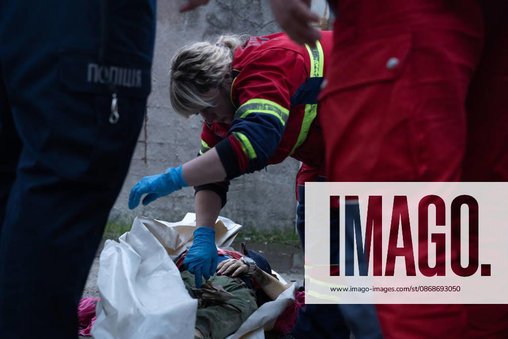 Local rescue workers identify the body of a woman following a Russian aerial attack on a bus repair warehouse in Kharkiv, Ukraine. Two people were killed in the attack, while emergency crews, firefighters and Red Cross volunteers worked to clear the rubble and search the damaged site. Kharkiv Ukraine - ZUMAm350 20261005_zip_m350_018