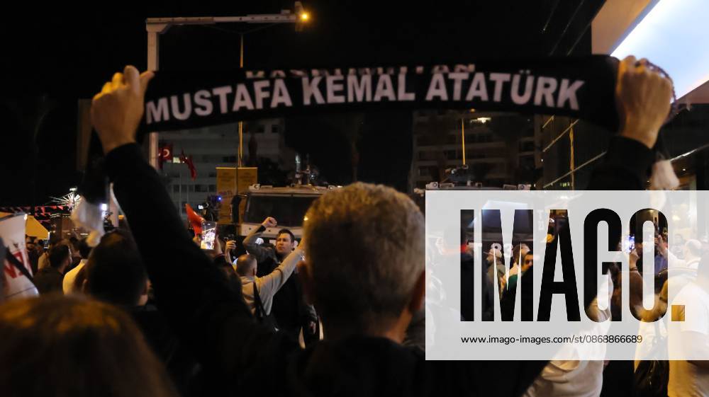 Â°Zmir, ToÂ¼rkiye: IZMIR, TURKEY, OCTOBER 7, 2026: Supporters of the opposition YENI Parti protest after Izmir Metropolitan Mayor Cemil Tugay joined President Recep Tayyip Erdogan s ruling AKP. Tugay was elected mayor as a CHP candidate in the 2024 local elections before leaving the party earlier this year. Protesters attempted to march toward Izmir City Hall carrying a black wreath, black carnations and a symbolic coffin while chanting for Tugay to resign. Police blocked parts of the march with barricades, riot police and water cannon vehicles, with protesters leaving flowers and the wreath near police barriers. Â°Zmir Türkiye - ZUMAq101 20261007_zna_q101_312