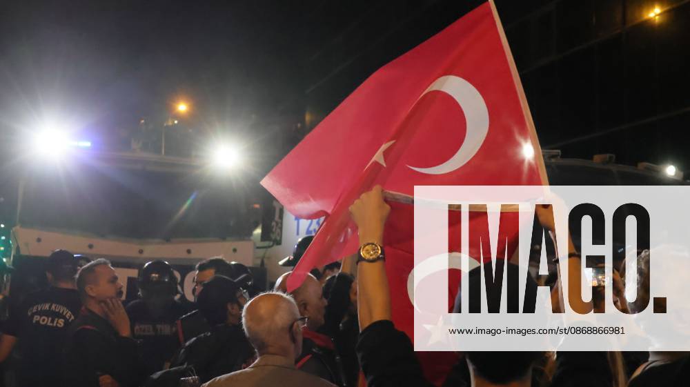 °Zmir, To¼rkiye: IZMIR, TURKEY, OCTOBER 7, 2026: Supporters of the opposition YENI Parti protest after Izmir Metropolitan Mayor Cemil Tugay joined President Recep Tayyip Erdogan s ruling AKP. Tugay was elected mayor as a CHP candidate in the 2024 local elections before leaving the party earlier this year. Protesters attempted to march toward Izmir City Hall carrying a black wreath, black carnations and a symbolic coffin while chanting for Tugay to resign. Police blocked parts of the march with barricades, riot police and water cannon vehicles, with protesters leaving flowers and the wreath near police barriers. °Zmir Türkiye - ZUMAq101 20261007_zna_q101_324