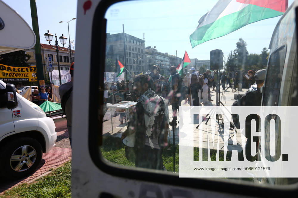 A pro-Palestinian demonstration is seen through the window of a parked vehicle as protesters gather with Palestinian flags and banners. Athens GREECE - ZUMAx103 20261010_zip_x103_004