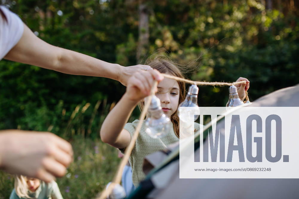 Dad and kids setting up tent together during summer camping trip. Kids and father preparing campsite for outdoor family vacation. model released