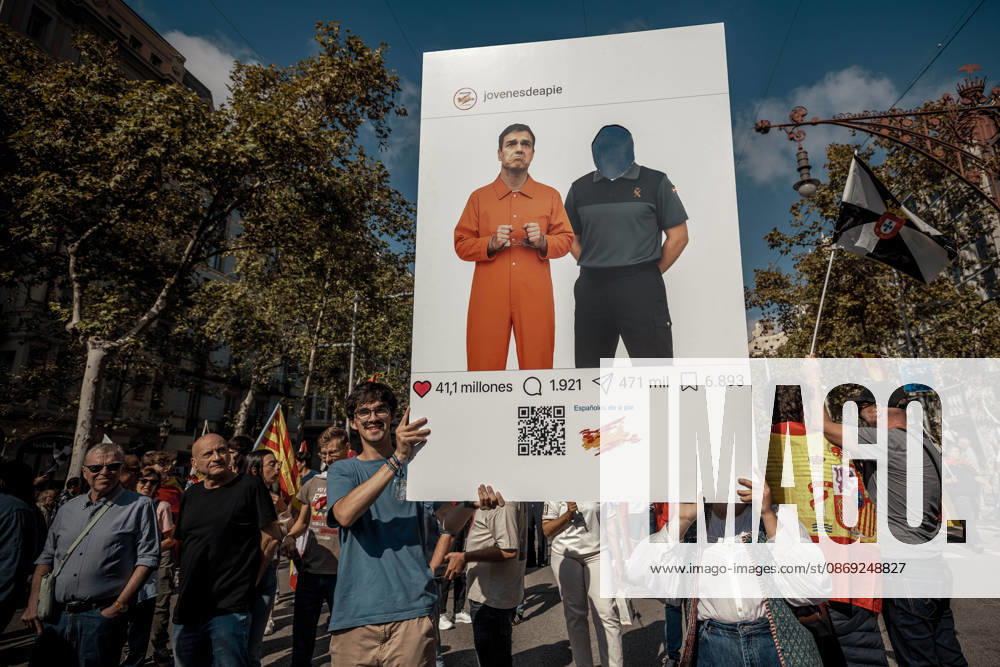 A demonstrator carries a placard styled as a social media post depicting Spanish Prime Minister Pedro So¡nchez in an orange prison uniform during a rally marking Spainâ€⠢s National Day. Barcelona Spain - ZUMAo105 20261012_fap_o105_009