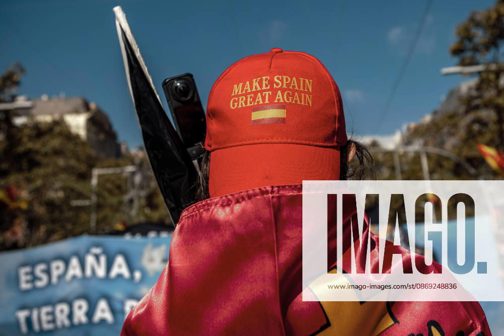A demonstrator wearing a Make Spain Great Again cap and draped in a Spanish flag is seen during a rally marking Spainâ€⠢s National Day. Barcelona Spain - ZUMAo105 20261012_fap_o105_013