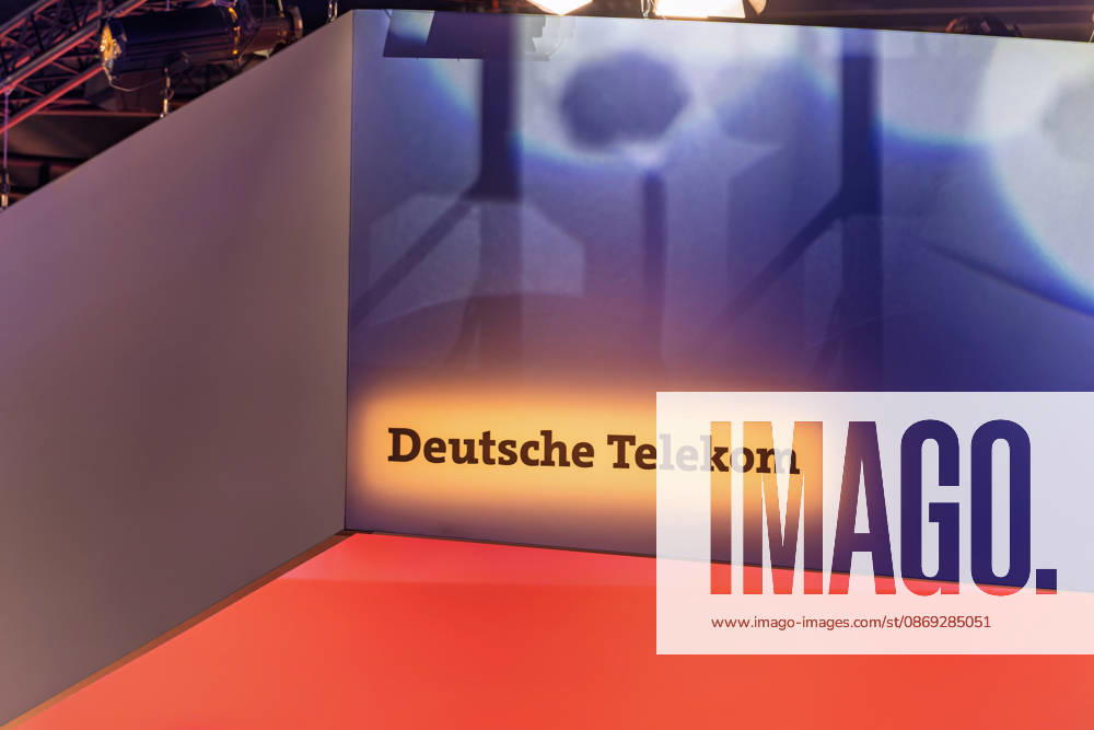 Berlin, 13.10.2026: Der beleuchtete Schriftzug Deutsche Telekom an einem Deckenaufbau über dem Messestand des Konzerns auf der Smart Country Convention in der Halle hub27. Die Telekom präsentiert dort Lösungen für die öffentliche Verwaltung, darunter KI-Agenten, souveräne Cloud-Angebote und einsatzkritische Kommunikation. Die Smart Country Convention (SCCON) ist die Kongressmesse für die Digitalisierung des öffentlichen Sektors und wird vom Digitalverband Bitkom gemeinsam mit der Messe Berlin veranstaltet. Vom 13. bis 15. Oktober 2026 treffen sich in der Halle hub27 Vertreter aus Bund, Ländern und Kommunen mit Unternehmen der Digitalwirtschaft, um über digitale Verwaltung, Smart City und digitale Souveränität zu diskutiere