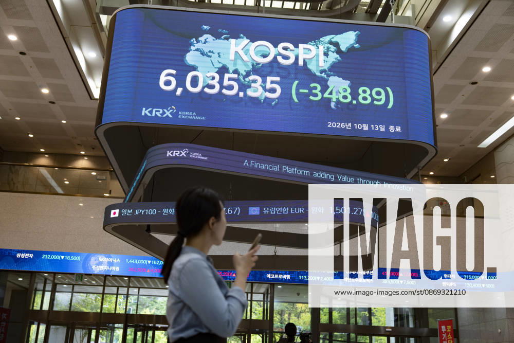 South Korea Stocks Plunge As KOSPI Drops Sharply At KRX In Seoul A Korea Exchange (KRX) employee looks at her smartphone while walking past a display board showing the closing KOSPI index at 6,035.35 (-348.89) in Yeouido, Seoul, South Korea, on October 13, 2026. Seoul Seoul South Korea