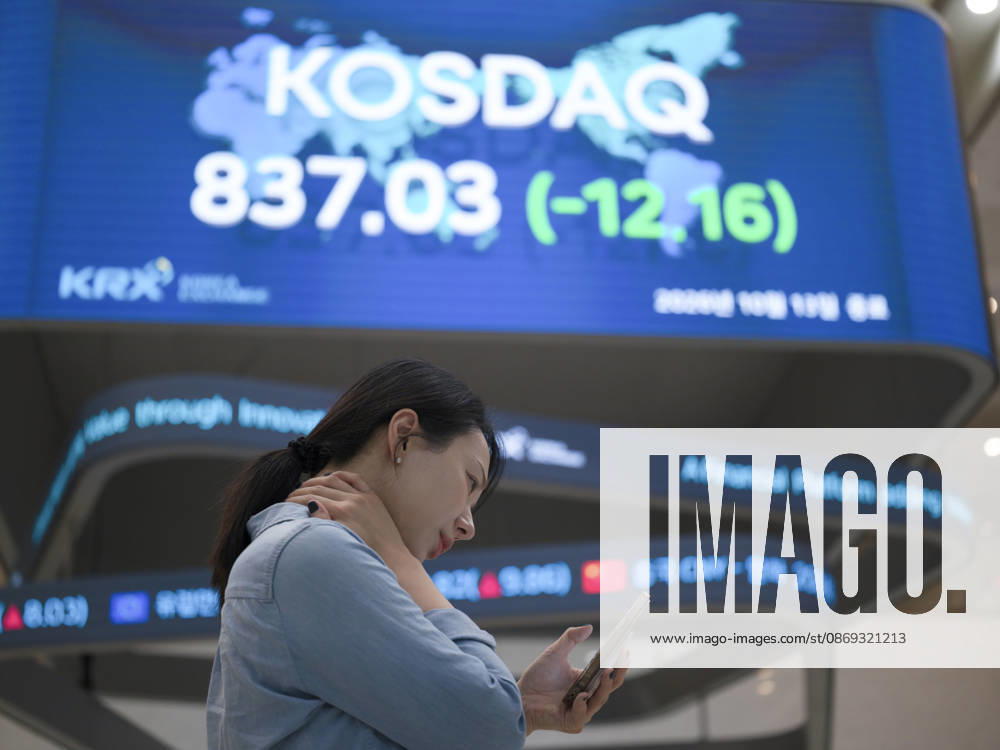South Korea Stocks Plunge As KOSPI Drops Sharply At KRX In Seoul A Korea Exchange (KRX) employee looks at her smartphone in front of a board displaying the closing KOSDAQ index at 837.03 (-12.16) in Yeouido, Seoul, South Korea, on October 13, 2026. Seoul Seoul South Korea