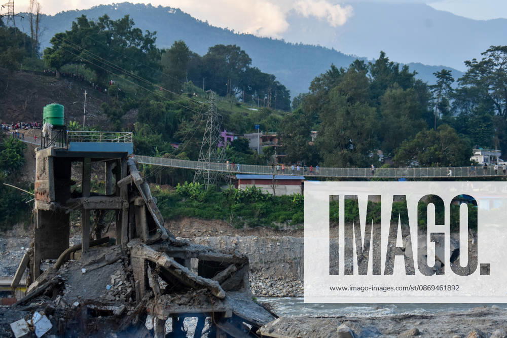 Aftermath of flash floods in Nepal NUWAKOT, NEPAL - OCTOBER 14 : People walk across a newly built suspension bridge over the Trishuli River, Nuwakot district, Nepal on October 14, 2026. Road and pedestrian connectivity has been restored with the construction of a new suspension bridge over the Trishuli River, allowing local residents to cross the river after the devastating floods damaged bridges and other infrastructure in the area. Sunil Pradhan Anadolu Nuwakot Nepal. Editorial use only. Please get in touch for any other usage.
