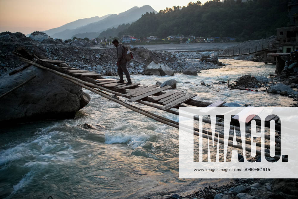 Aftermath of flash floods in Nepal RASUWA, NEPAL - OCTOBER 14 : A man crosses a temporary bridge over a river in Rasuwa district, Nepal on October 14, 2026. Road and pedestrian connectivity has been restored with the construction of a new suspension bridge over the Trishuli River, allowing local residents to cross the river after the devastating floods damaged bridges and other infrastructure in the area. Sunil Pradhan Anadolu Rasuwa Nepal. Editorial use only. Please get in touch for any other usage.