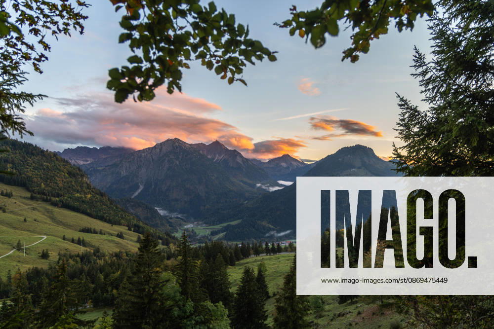 Herbstabend im Allgäu Die Wolken am Himmel leuchten im Licht der Abendsonne über den Gipfeln der Allgäuer Alpen., Bad Hindelang Bayern Deutschland