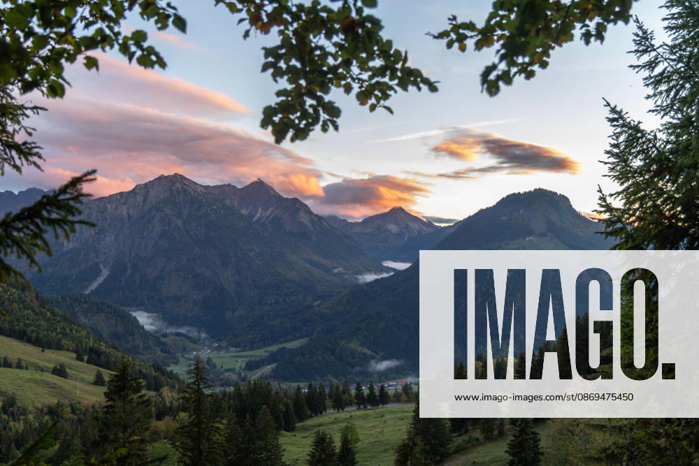 Herbstabend im Allgäu Die Wolken am Himmel leuchten im Licht der Abendsonne über den Gipfeln der Allgäuer Alpen., Bad Hindelang Bayern Deutschland