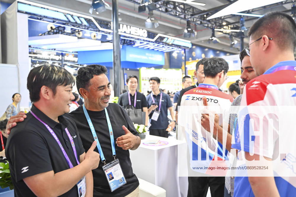Zhang Xue (L) poses for a photo with an overseas buyer at the booth of Chinese motorcycle brand Zhangxue Motorcycle (ZXMOTO) during the 140th China Import and Export Fair (Canton Fair) on October 15, 2026 in Guangzhou, Guangdong Province of China. The fair runs in three phases until November 4, covering a total exhibition area of 1.55 million square meters.