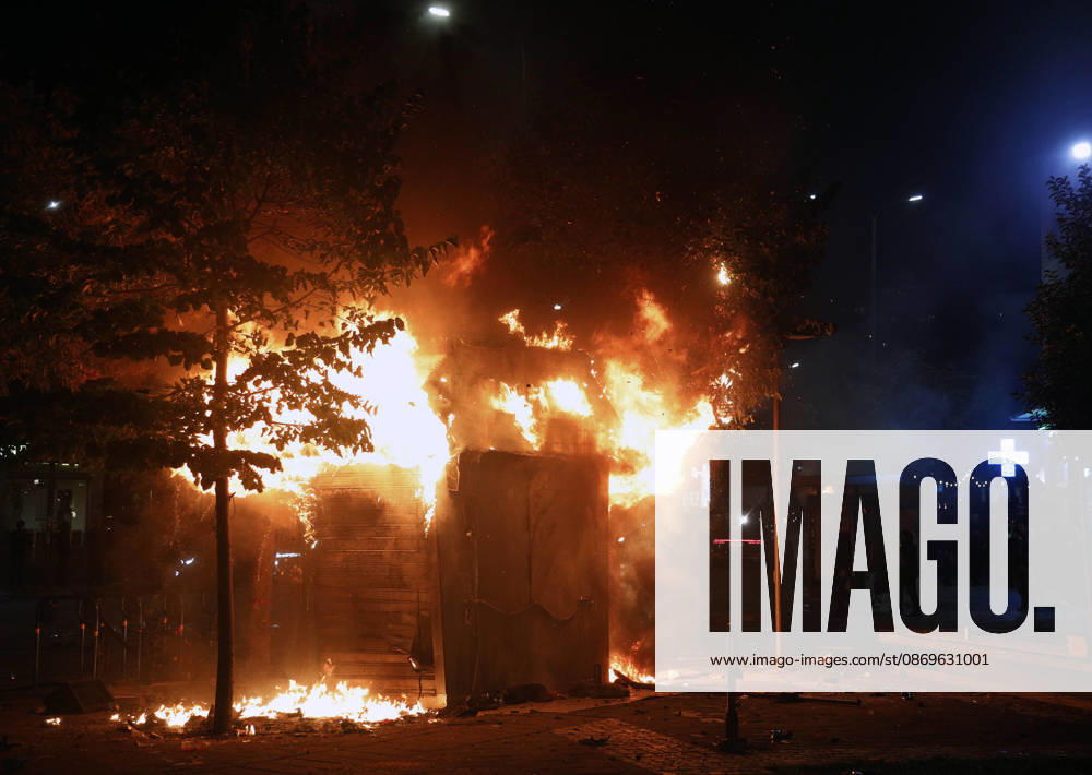Protesters Clash with Police During a Demonstration in Tirana, Albania. Protesters walk in front of a burning kiosk during an anti-government demonstration in central Tirana on October 15, 2026, as protests continued for a third consecutive day over university conditions and demands for the resignation of Albanian Prime Minister Edi Rama. The latest rally follows two nights of violence in the capital, during which protesters and riot police clashed, police used water cannons and tear gas, and demonstrators damaged government offices and shops and set fire to several buildings. Light Studio Agency Malton Dibra Tirana Albania