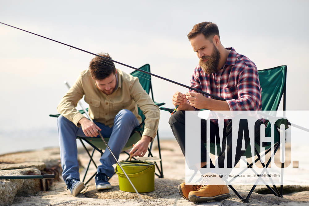 Freunde anpassung angelruten mit köder auf pier freizeit und menschen konzept - freunde oder fischer anpassung angelruten mit köder auf pier (License=RF) ,model released, Symbolfoto