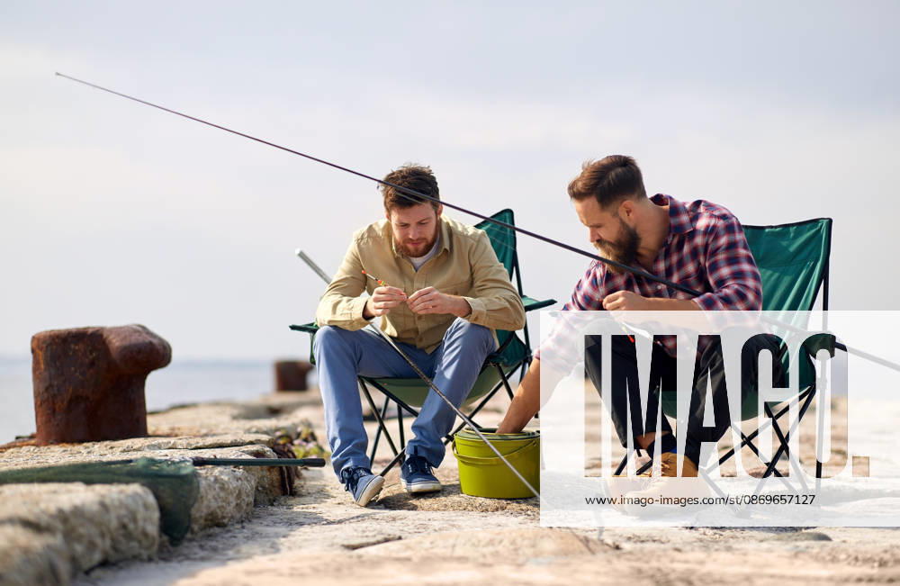 Freunde anpassung angelruten mit köder auf pier freizeit und menschen konzept - freunde oder fischer anpassung angelruten mit köder auf pier (License=RF) ,model released, Symbolfoto