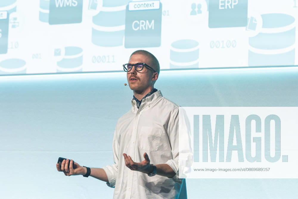 Berlin, 16.10.2026: Speaker Felix Mutzl spricht auf der Bühne der NeulandPro Connect 2026 vor einer Folie mit Unternehmenssoftware wie CRM- und ERP-Systemen. Die zweitägige KI-Konferenz NeulandPro Connect 2026 findet am 16. und 17. Oktober im Westhafen Event & Convention Center (WECC) in Moabit statt, einem historischen Speichergebäude am Berliner Westhafen. Veranstalter ist NeulandPro, eine Bildungs- und Medienmarke rund um Künstliche Intelligenz. Mit Vorträgen, Workshops und Hackathons richtet sich die Konferenz vor allem an kleine und mittelständische Unternehmen, Gründer und Führungskräfte, die KI praktisch einsetzen wollen; erwartet werden bis zu 1.000 Gäste. NeulandPro Connect 2026 - KI-Konferenz in Berlin