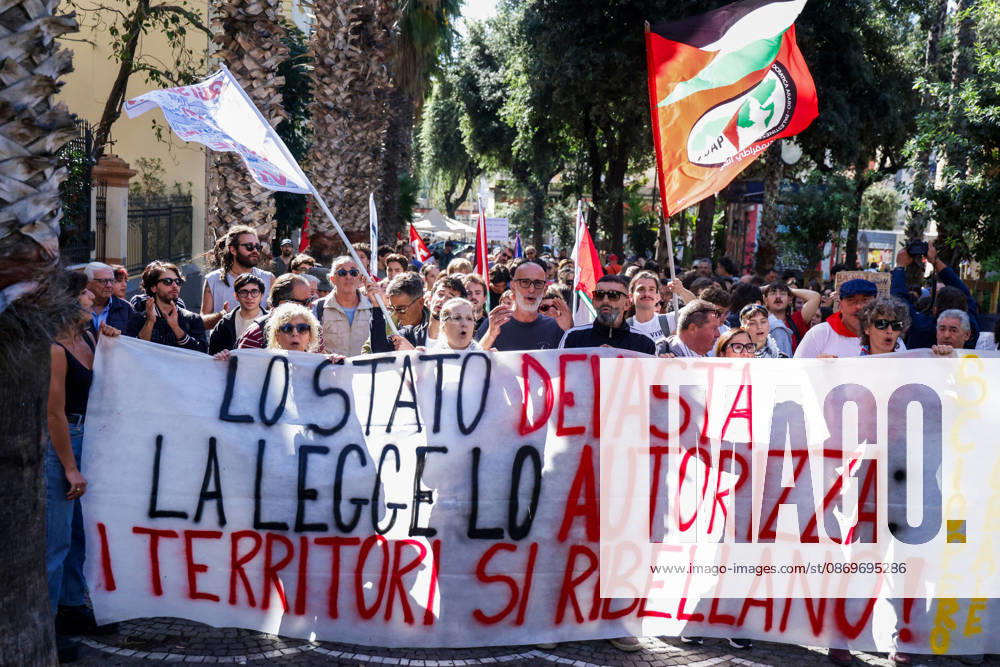 IPA89763003 - NAPLES, ITALY — OCTOBER 16, 2026: Environmental activists, students, and unemployed people take to the streets in the Bagnoli district of Naples to protest the municipal administration’s handling of the environmental remediation of the former Italsider steelworks site. The demonstration focuses on the ongoing redevelopment work in the area, where facilities for the 38th Louis Vuitton America’s Cup—scheduled to take place in Naples in 2027—are being built. Protesters raise concerns about environmental protection, the remediation process, and the project’s impact on the local community.