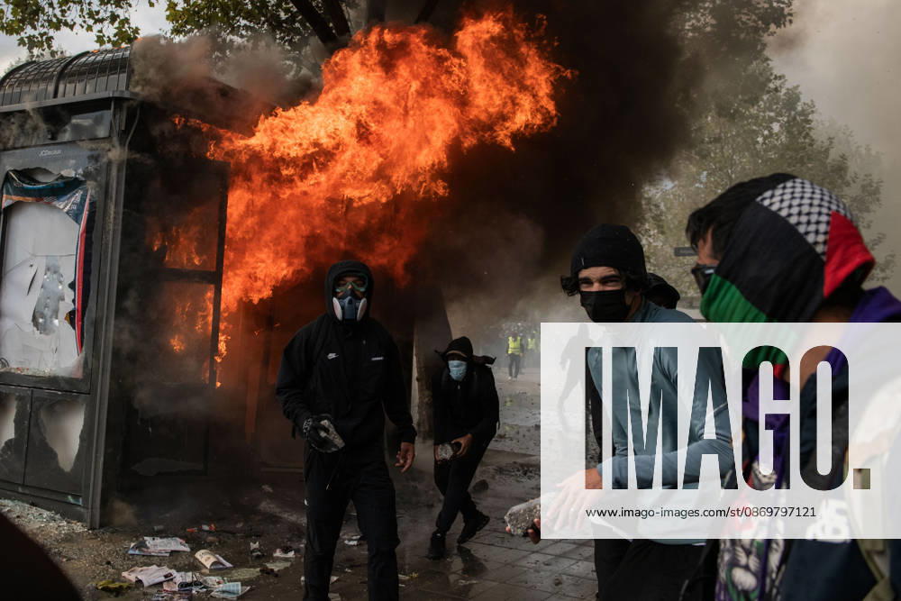 Paris, protest of students and worker against the increasing cost of living. Situation escalated from the morning till late night, with clashes, barricades, cars burned and shops looted. Police responded with tear gas and hidrants. In the picture: protester threowing rosk in front of a kiosk set on fire Paris France - ZUMAb283 20261017_zaf_b283_006