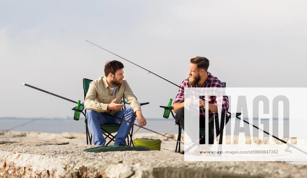 Freunde anpassung angelruten mit köder auf pier freizeit und menschen konzept - freunde oder fischer anpassung angelruten mit köder auf pier (License=RF) ,model released, Symbolfoto