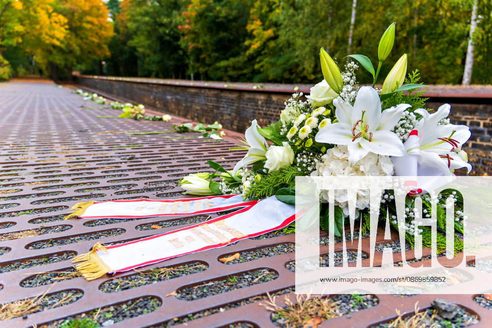 Berlin-Grunewald, 18.10.2026: Ein Gesteck mit weißen Lilien und Hortensien des Bezirks Charlottenburg-Wilmersdorf liegt nach der Gedenkveranstaltung zum 85. Jahrestag des Beginns der nationalsozialistischen Deportationen von Jüdinnen und Juden aus Berlin auf den Stahlplatten des Mahnmals Gleis 17; dahinter sind entlang der Bahnsteigkante weiße Rosen abgelegt. Das Mahnmal Gleis 17 am Bahnhof Grunewald erinnert an die Deportation von mehr als 50.000 Berliner Jüdinnen und Juden; der erste Zug fuhr am 18. Oktober 1941 in das Ghetto Litzmannstadt (Å?odź). 186 Stahlgussplatten entlang der Gleiskanten verzeichnen chronologisch jeden Transport mit Datum, Zahl der Deportierten und Zielort, bis zum letzten Zug am 5. Januar 1945 nach Sachsenhaus
