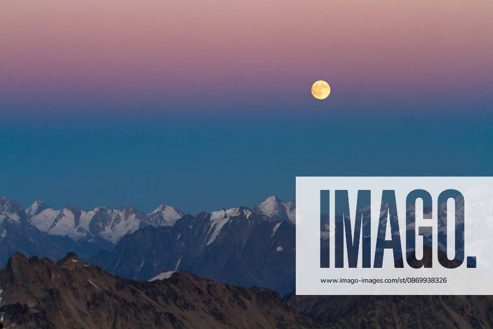 A full moon shines over snowy mountains at dusk El brusskiy, Karachay-Cherkessia, Russia CR_YUKI261018B-2149184-01 ,model released, Symbolfoto ,property released
