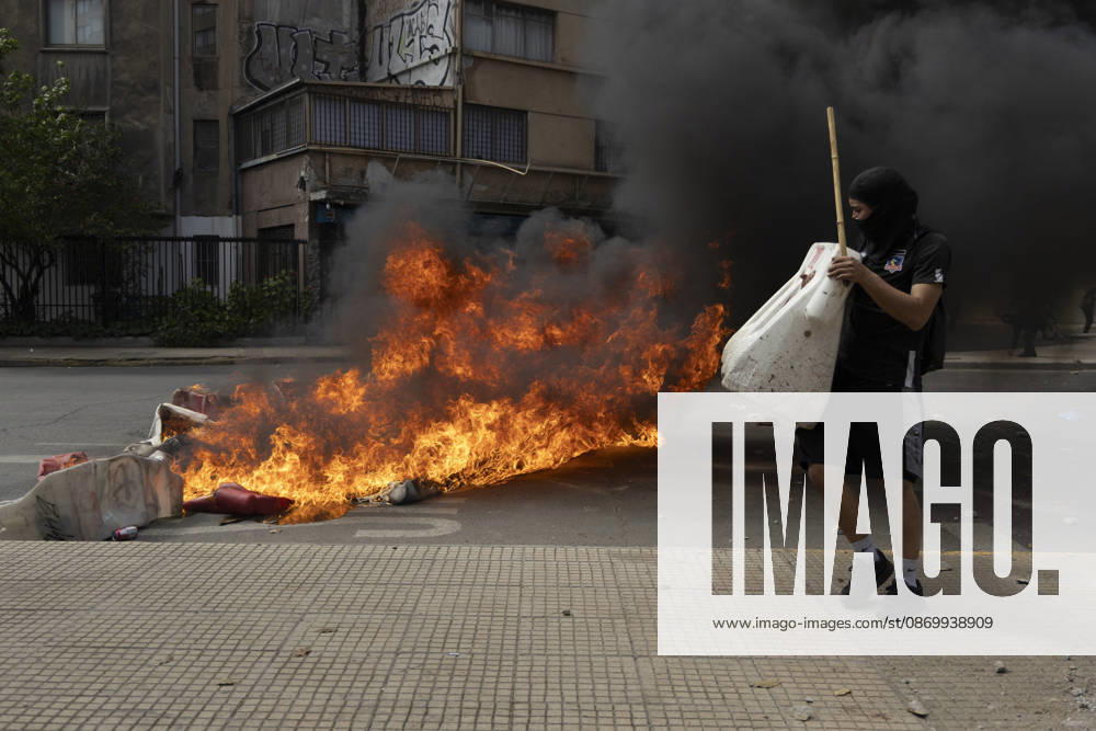 A man walks past a burning barricade during the demonstration. In the center of the capital of Chile, different incidents took place between demonstrators and the police. The riots were carried out during the commemoration of the 7 years after the social outcast that happened on October 18, 2019. Santiago Chile - ZUMAs197 20261019_aaa_s197_001