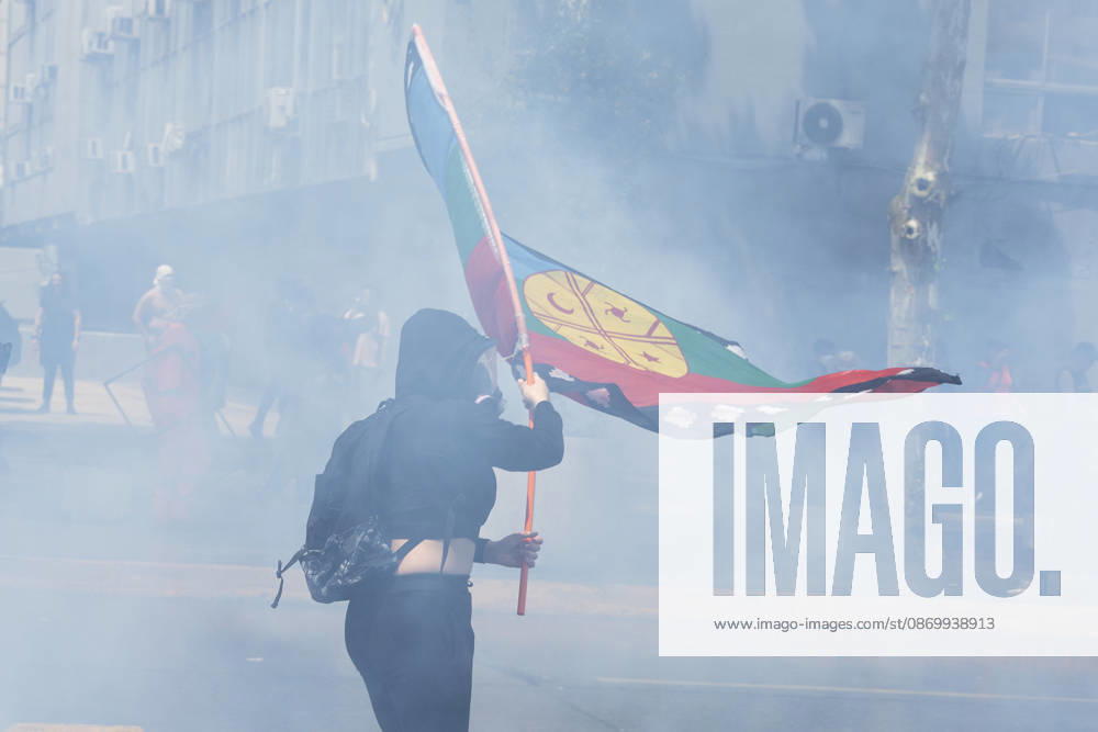 A demonstrator in the smoke flies a flag that symbolizes the Mapuche people. In the center of the capital of Chile, different incidents took place between demonstrators and the police. The riots were carried out during the commemoration of the 7 years after the social outcast that happened on October 18, 2019. Santiago Chile - ZUMAs197 20261019_aaa_s197_004