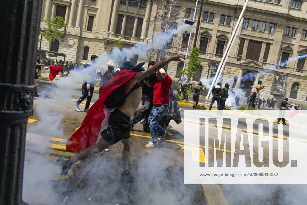 A man returns a tear gas bomb at the police. In the center of the capital of Chile, different incidents took place between demonstrators and the police. The riots were carried out during the commemoration of the 7 years after the social outcast that happened on October 18, 2019. Santiago Chile - ZUMAs197 20261019_aaa_s197_009