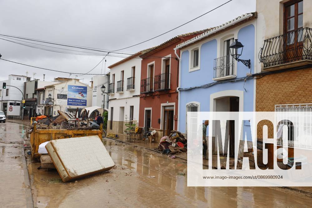 The Valencian Regional Government is preparing a lockdown order for the southern coast of Valencia and the northern coast of Alicante due to the rains. Several people are clearing mud from the streets while furniture they had to remove due to flooding caused by the heavy rains piles up, on October 19, 2026, in Els Poblets, Valencian Community, Spain. The Valencian Regional Government is preparing a lockdown order for the southern coast of Valencia and the northern coast of Alicante in response to the emergency declared due to the rains brought by Storm Adam, as announced by the Regional Minister of Emergencies and the Interior early this morning, October 19, from the Emergency Coordination Center (CCE) October 19, 2026, Valencia, Valencian