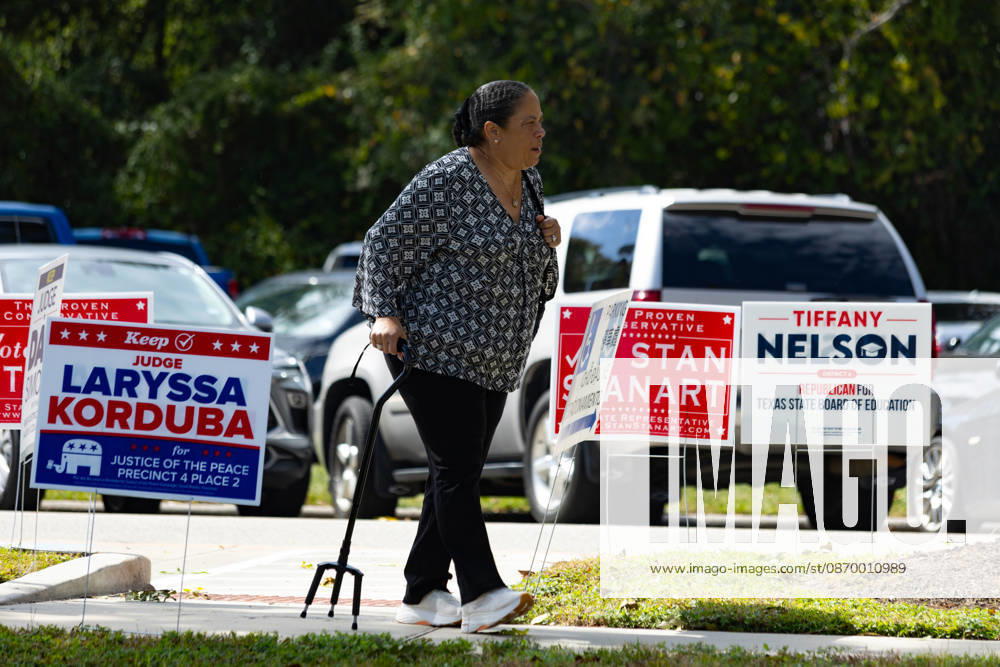 A woman walks past campaign advertising during the early voting period at the George Bush center in Houston, Texas, United States, 19 October 2026. Early voting begins in several key states in the United States !ACHTUNG: NUR REDAKTIONELLE NUTZUNG!