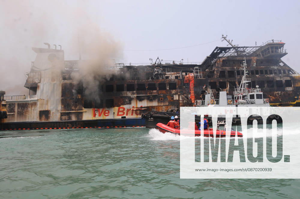 Efforts are underway to extinguish a fire that broke out on a passenger ferry in Indonesia s Cilegon PELABUHAN MERAK, CILEGON, INDONESIA - OCTOBER 21: Fireboats take turns spraying water onto the passenger ferry KMP Batumandi to cool down the vessel after it caught fire while preparing to dock off Merak Port in Cilegon, Banten, Indonesia on Wednesday, October 21, 2026. The vessel caught fire on Tuesday, October 20, and rescue operations remain underway as the ship continues to emit smoke. Water is continuously sprayed to cool the vehicle deck containing numerous cars, motorcycles, buses, and trucks, while authorities confirm no fatalities have been reported. Dasril Roszandi Anadolu Pelabuhan Merak Indonesia. Editorial use only. Please get