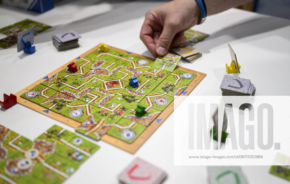 Feature, das Spiel Carcassonne Labyrinth aus der Verlagskooperation Ravensburger und Hans im Glück, eine Hand legt ein Plättchen, Neuheitenschau, am 21.10.2026 Messe SPIEL Essen vom 22.10 - 25.10.2026 in E s s e n Deutschland. Grugahalle