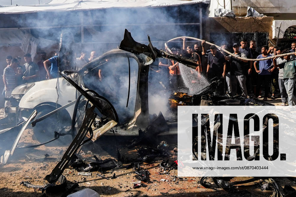 Gaza Rescuers Inspect Strike Wreckage Smoke rises from the twisted metal of a gutted vehicle as water is sprayed over its blackened remains and onlookers stand nearby in the Tal al-Hawa neighborhood of Gaza City, Gaza Strip, on October 22, 2026. The Israeli strike on a vehicle in the Tal al-Hawa neighborhood killed at least one person and injured several others, Palestinian medical officials said. Casualties were taken to Al-Shifa Medical Complex as Civil Defense crews extinguished flames and examined the wreckage, while residents gathered at the scene amid continued Israeli military operations in the Gaza Strip. Gaza City Gaza Strip Palestinian Territories