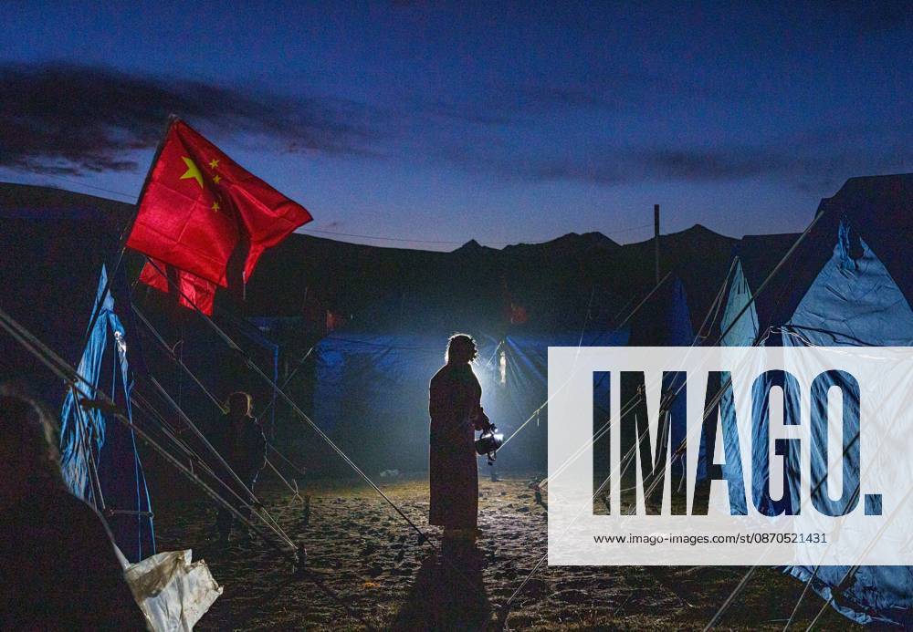 (261023) -- NAGQU, Oct. 23, 2026 -- A villager prepares to fill her kettle with hot water at a temporary resettlement site of an earthquake-hit village in Maru Township of Baqen County, Nagqu City, southwest China s Xizang Autonomous Region, Oct. 23, 2026. China has allocated 50 million yuan (about 7.5 million U.S. dollars) in emergency disaster relief funds and earmarked another 30 million yuan for recovery efforts following a 7.0-magnitude earthquake in southwest China s Xizang Autonomous Region. The earthquake struck Baqen County of the city of Nagqu at 10:33 p.m. on Thursday, leaving 16 people dead and 54 injured. ) (SpotNews) CHINA-XIZANG-NAGQU-EARTHQUAKE-RESETTLEMENT (CN) TenzinxNyida