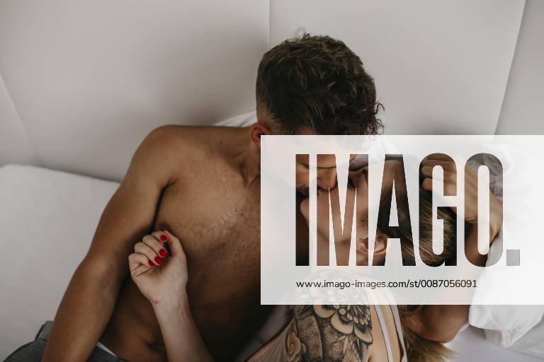 Romantic young couple kissing in bed model released Symbolfoto property released LHPF00026