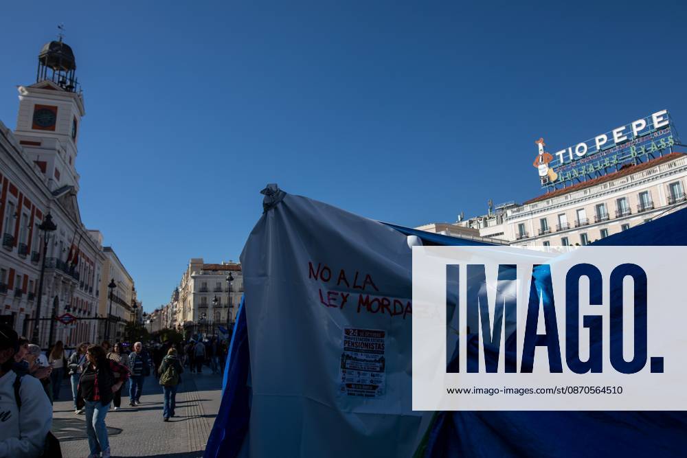 A banner with the phrase No to the gag law (Ley Mordaza) can be seen at Puerta del Sol..Tents remain set up by housing rights activists, who organized the occupation of the square in response to the eviction of Maricarmen a woman in her eighties from her home, carried out by a real estate investment fund. Madrid Spain - ZUMAs197 20261023_aaa_s197_151