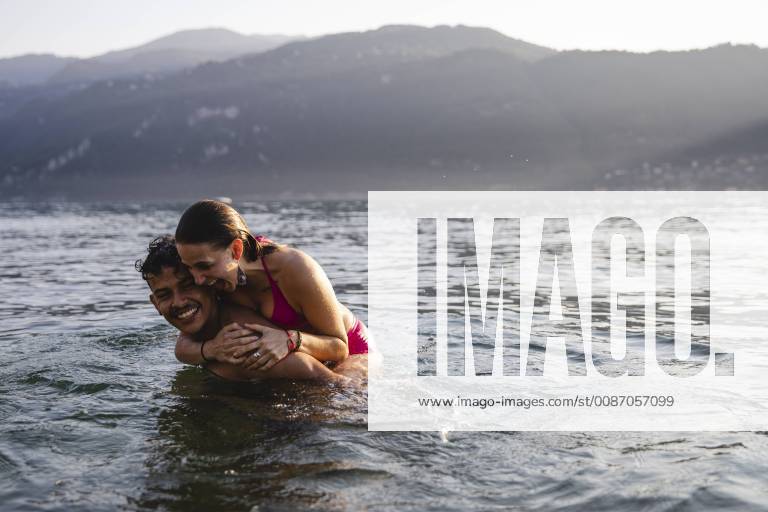 Happy playful young couple in a lake model released Symbolfoto MRAF00289