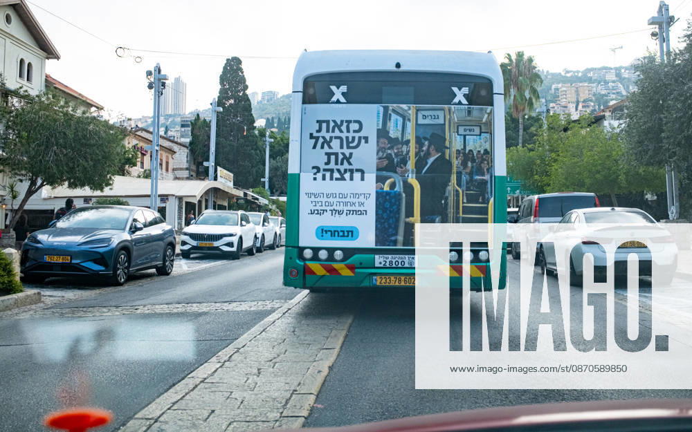 Wahlen in Israel 2026. Israel, Haifa am 24. Oktober, 2026: Ein Linienbus des öffentlichen Nahverkehrs in Haifa mit einem großflächigen Wahlkampfaufkleber auf der Rückseite. Das Motiv zeigt orthodoxe jüdische Männer im vorderen Bereich eines Busses unter einem Schild mit der Aufschrift Männer, während junge säkulare Frauen im hinteren Bereich unter einem Schild Frauen sitzen. Der Slogan lautet sinngemäß: Willst du ein Israel wie dieses? Vorwärts mit dem Block des Wandels oder rückwärts mit Bibi (Benjamin Netanjahu). Deine Stimme entscheidet. Wähle! (in der weiblichen Form.)