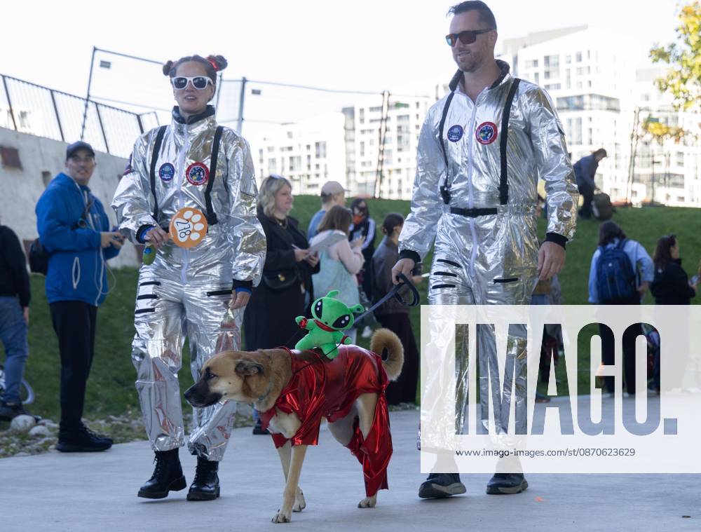 (261025) -- TORONTO, Oct. 25, 2026 -- A dog and its owners take part in Howl oween at the Bentway, a dog-and-owner costume contest, in Toronto, Canada, on Oct. 24, 2026. The annual event was held here on Saturday, bringing Halloween fun for dogs and their owners. (Photo by Xinhua) CANADA-TORONTO-HOWL OWEEN-DOG & OWNER COSTUME CONTEST ZouxZheng