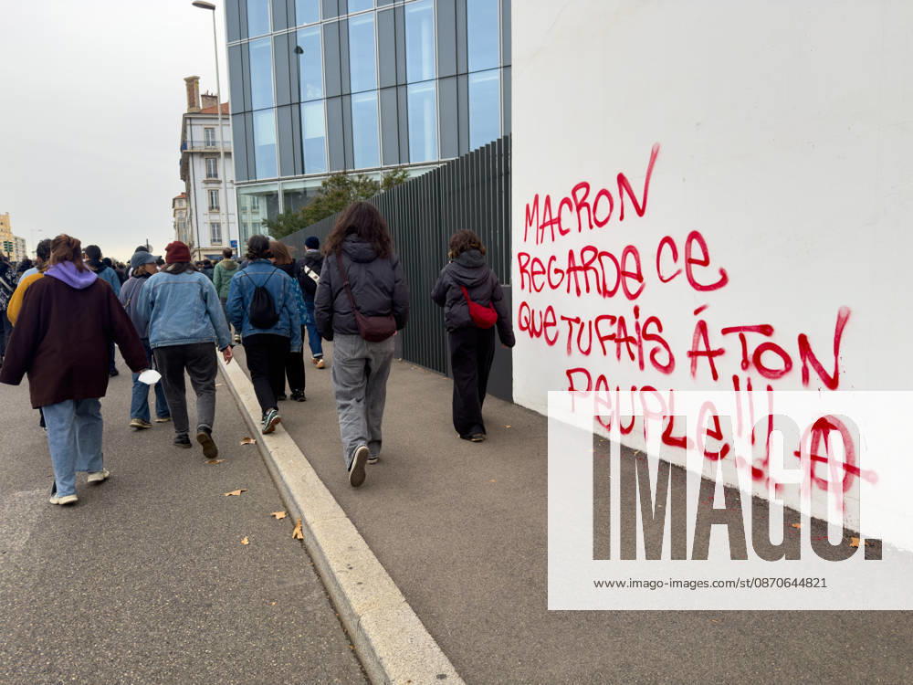Lyon France Protests October 24 Demonstrators walk past graffiti reading Macron, remember what you are doing to your people during a protest in Lyon, France on October 24, 2026. Authorities deployed around 70,000 security personnel across France for renewed protests over the cost of living, after unrest a week earlier saw public buildings damaged, hundreds of shops looted and about 2,700 people arrested. Lyon Rhone Alpes France