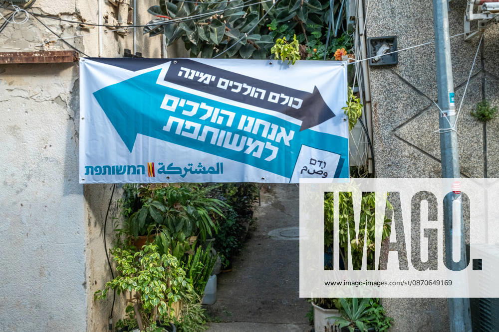 Wahlen in Israel 2026. Israel, Haifa am 24. Oktober, 2026: Wahlplakat der arabischen Parteienallianz Vereinte Liste ,gespannt zwischen zwei Mauern einer begrünten Gasse im überwiegend von arabischen Bürgern bewohnten Stadtteil Wadi Nisnas in Haifa. Der Slogan lautet auf Hebräisch: Alle gehen (Richttung) Rechts, wir gehen zu der Vereinten.