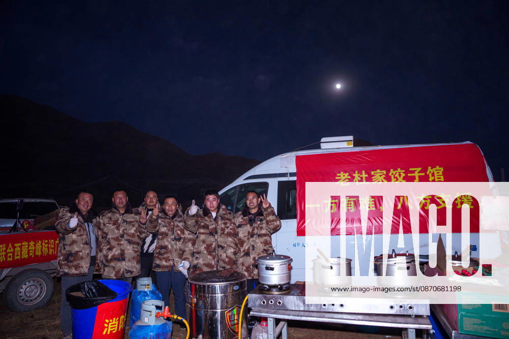 (261025) -- BAQEN, Oct. 25, 2026 -- Du Guoping (1st R) poses for a photo with his staff members at a temporary shelter in Maru Township of Baqen County, Nagqu City, southwest China s Xizang Autonomous Region, Oct. 24, 2026. After a 7.0-magnitude earthquake struck Baqen County in Nagqu, southwest China s Xizang Autonomous Region, on Thursday, Du Guoping, owner of a dumpling restaurant in Xigaze, postponed the opening of his two new restaurants and headed to the disaster zone with his staff. It took only about 10 minutes to make the decision that we would go to Baqen and cook dumplings for earthquake-affected residents, Du said. The team loaded more than 1,500 kilograms of dumplings onto vehicles and set off from Xigaze at midnight on