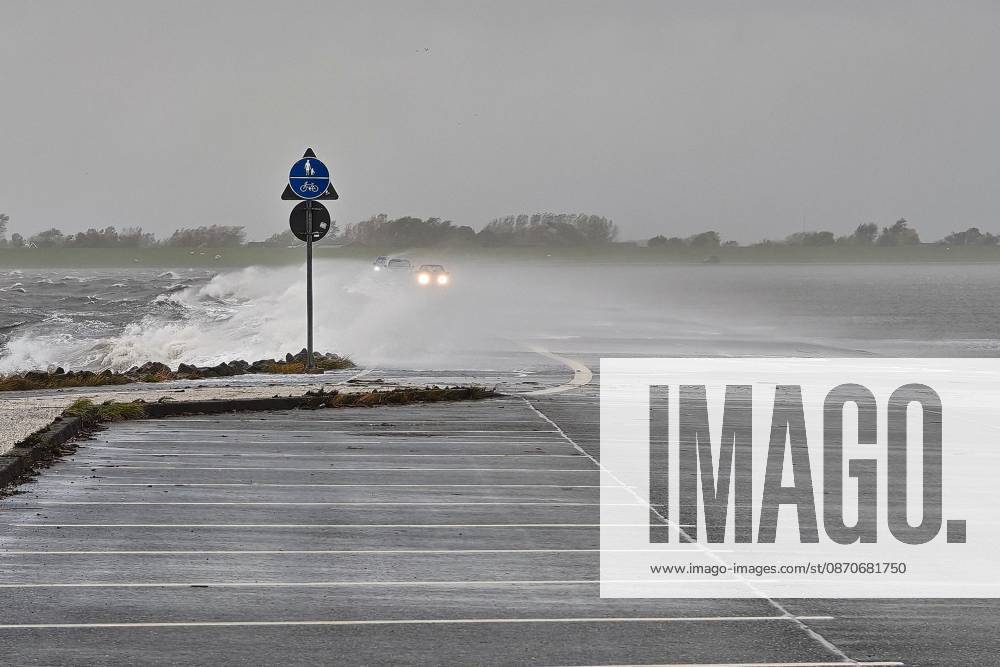 Pellworm, Schleswig-Holstein, Deutschland, 25.10.2026: Sturm an der Nordsee: Autos fahren über den Damm zum Tiefwasseranleger