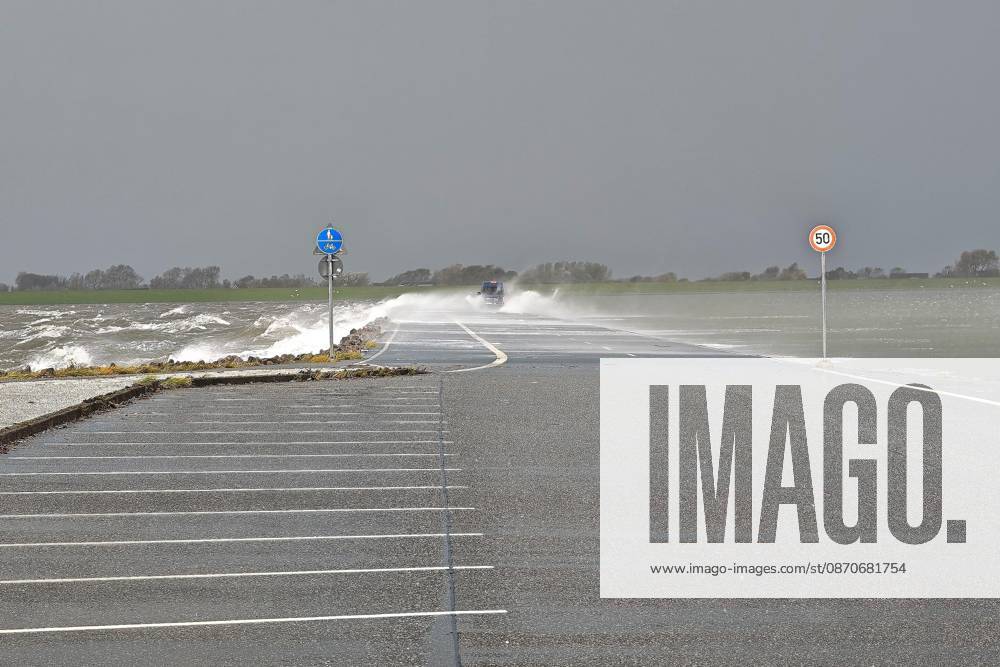 Pellworm, Schleswig-Holstein, Deutschland, 25.10.2026: Sturm an der Nordsee: Autos fahren über den Damm zum Tiefwasseranleger
