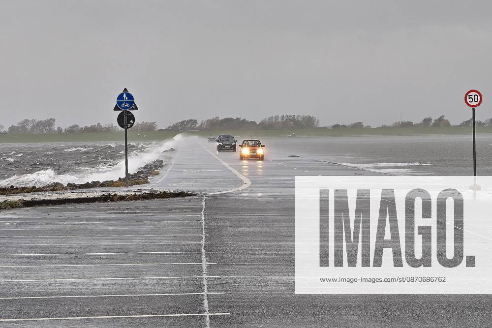 Pellworm, Schleswig-Holstein, Deutschland, 25.10.2026: Sturm an der Nordsee: Autos fahren über den Damm zum Tiefwasseranleger.