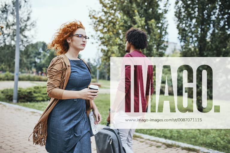 Man and woman going to work, passing each other model released Symbolfoto ZEDF01504