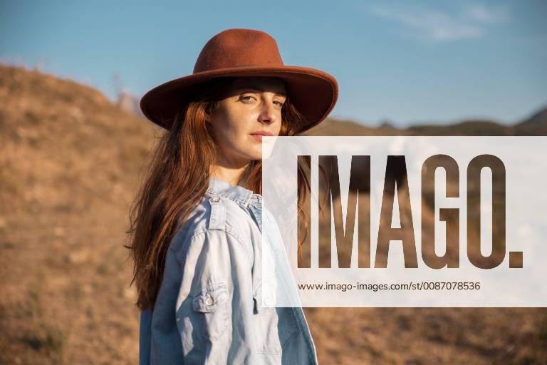 Portrait of young woman wearing a hat in rural landscape model released Symbolfoto AFVF01569