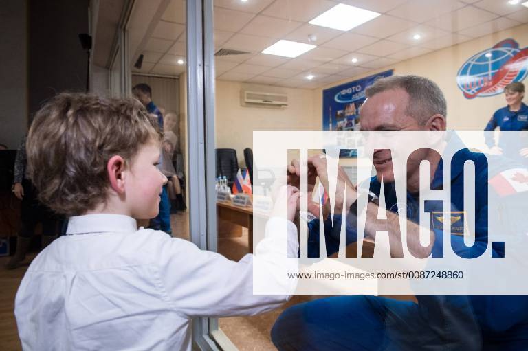 Expedition 58 Flight Engineer David Saint-Jacques of the Canadian Space Agency (CSA), right, who is in quarantine, makes a heart with his hands for his son, at the conclusion of a press conference, on December 2, 2018, at the Cosmonaut Hotel in Baikonur, Kazakhstan. Launch of the Soyuz rocket is scheduled for December 3 and will carry Saint-Jacques, Soyuz Commander Oleg Kononenko of Roscosmos, and Flight Engineer Anne McClain of NASA into orbit to begin their six and a half month mission on the International Space Station. NASA WAX2018120212 AUBREYxGEMIGNANI