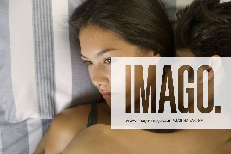 Young couple being intimate in bed, woman looking disinterested